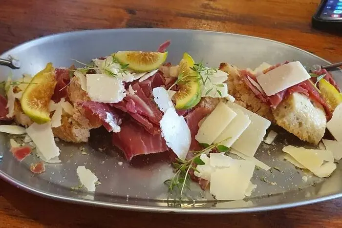 Bread topped with cured ham, cheese shavings and figs from Tapas e Lendas’ own food gallery.