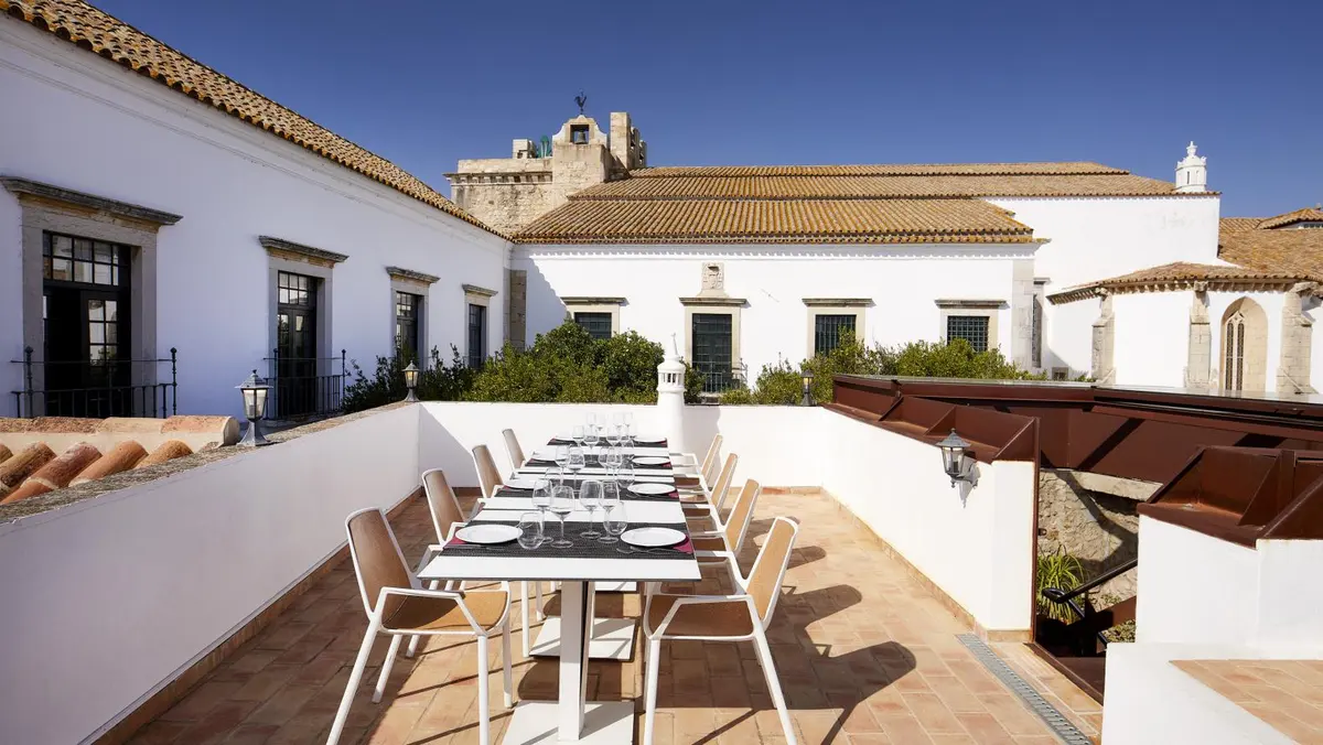A long table set on Tertúlia Algarvia’s terrace among the white buildings of Faro’s old town.