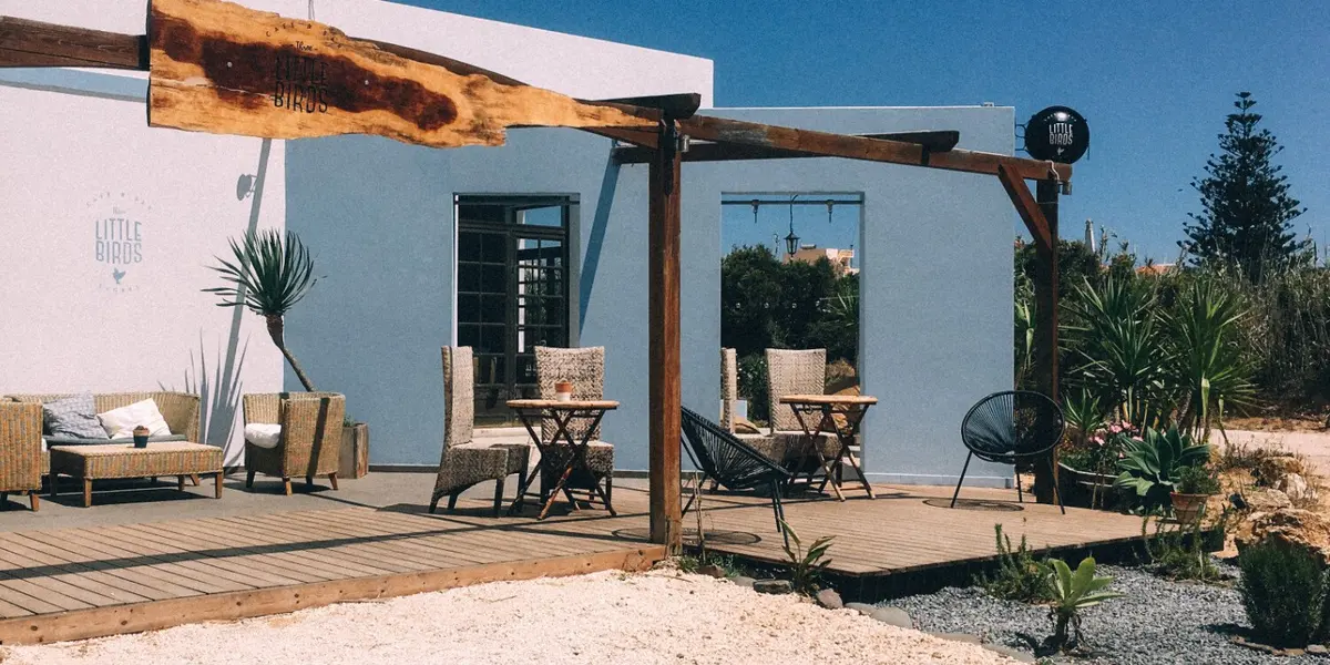 Outdoor seating and the pink exterior of Three Little Birds