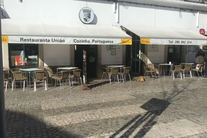 Street-side tables under the Restaurante União awning in São Brás de Alportel.