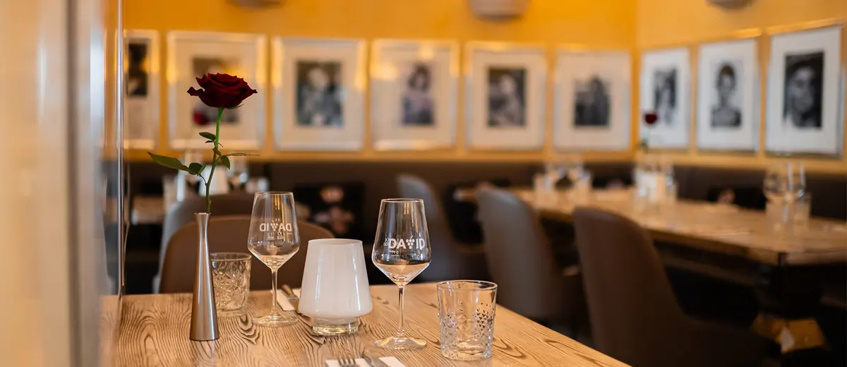 Dining tables and framed portraits on the walls at Villa Medici in Carvoeiro