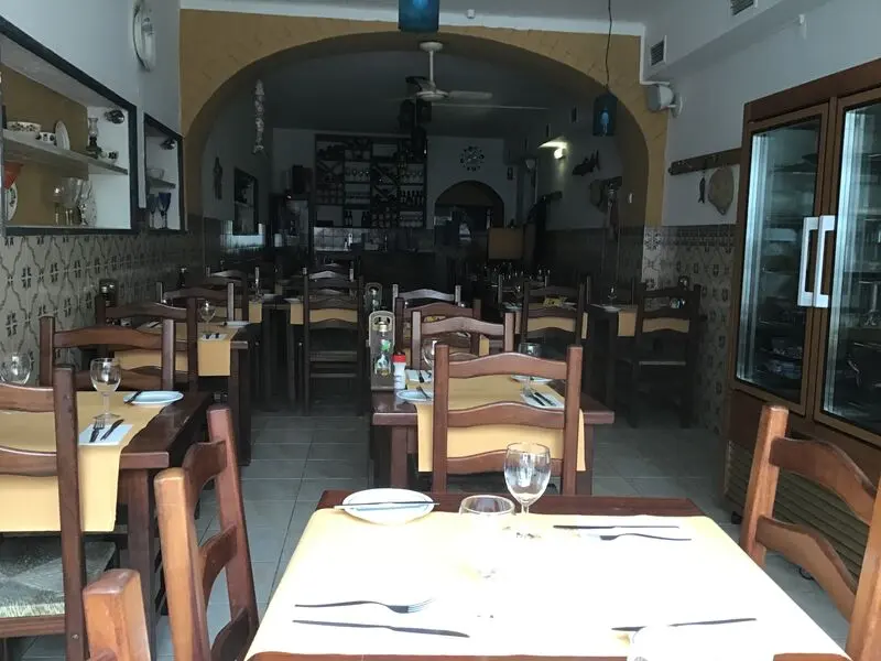 Laid wooden tables inside Zeca da Bica’s dining room in Tavira.