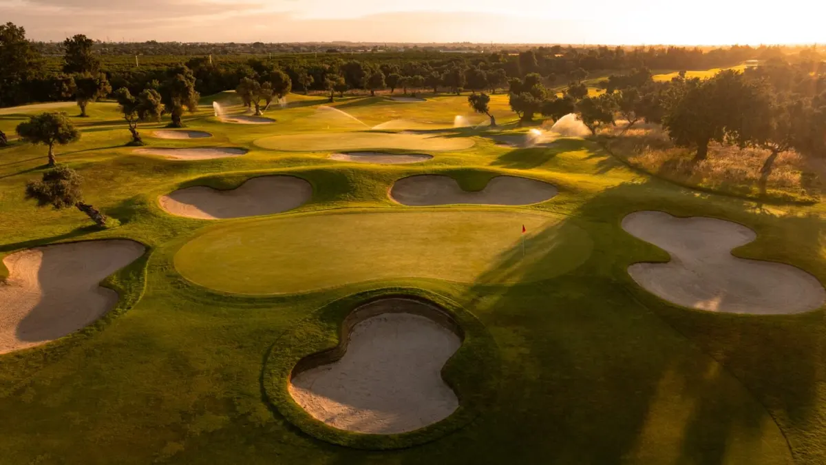 Bunkers and greens among olive trees on Quinta de Cima at sunset