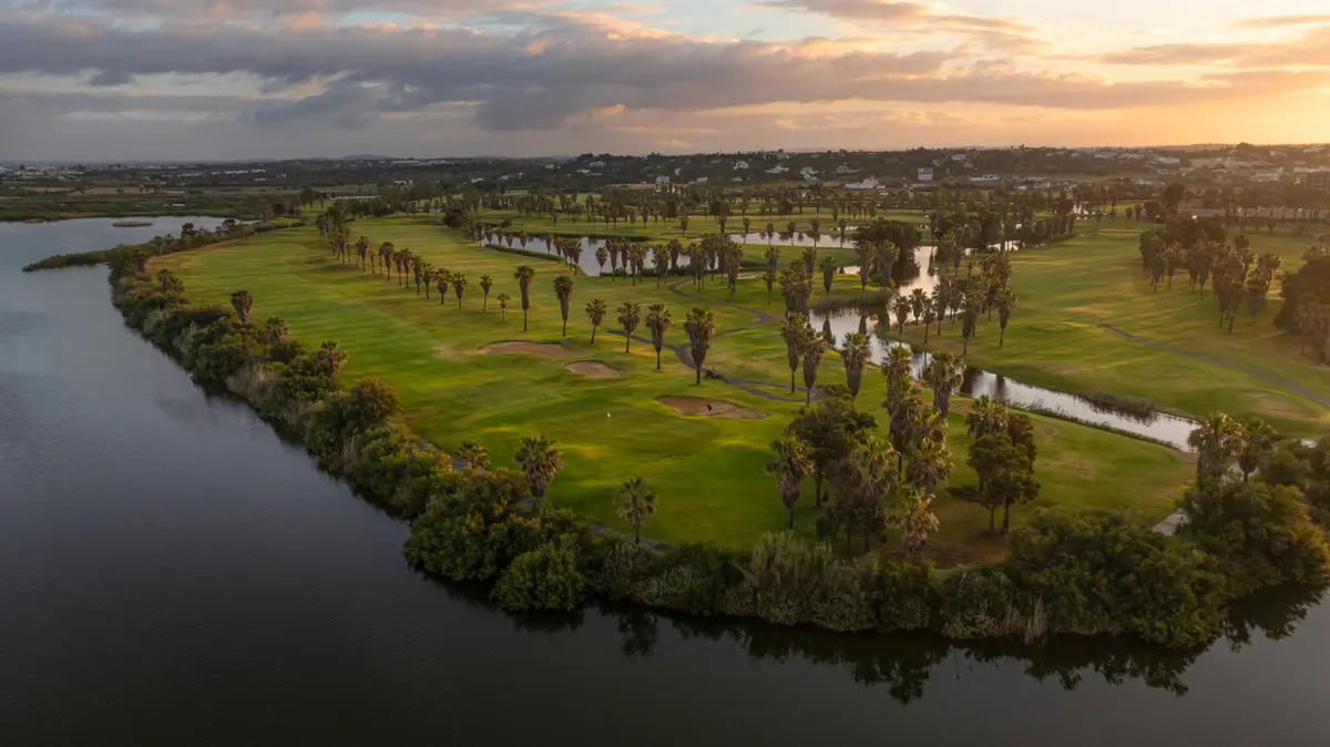 Palm-lined fairways and water hazards at Salgados Golf Club at sunset