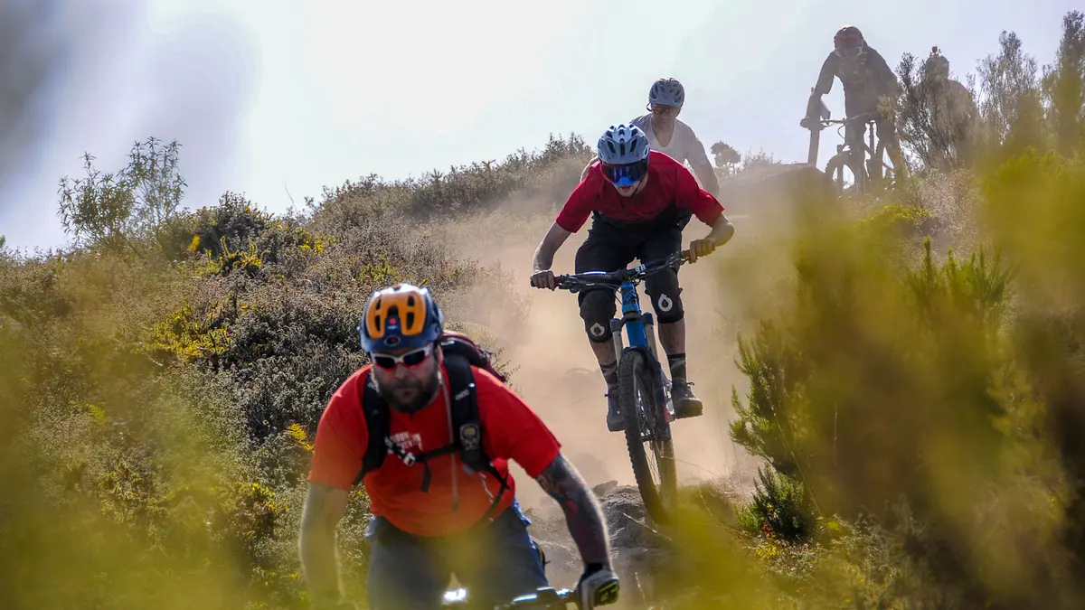Mountain bikers following a dusty track through scrubland
