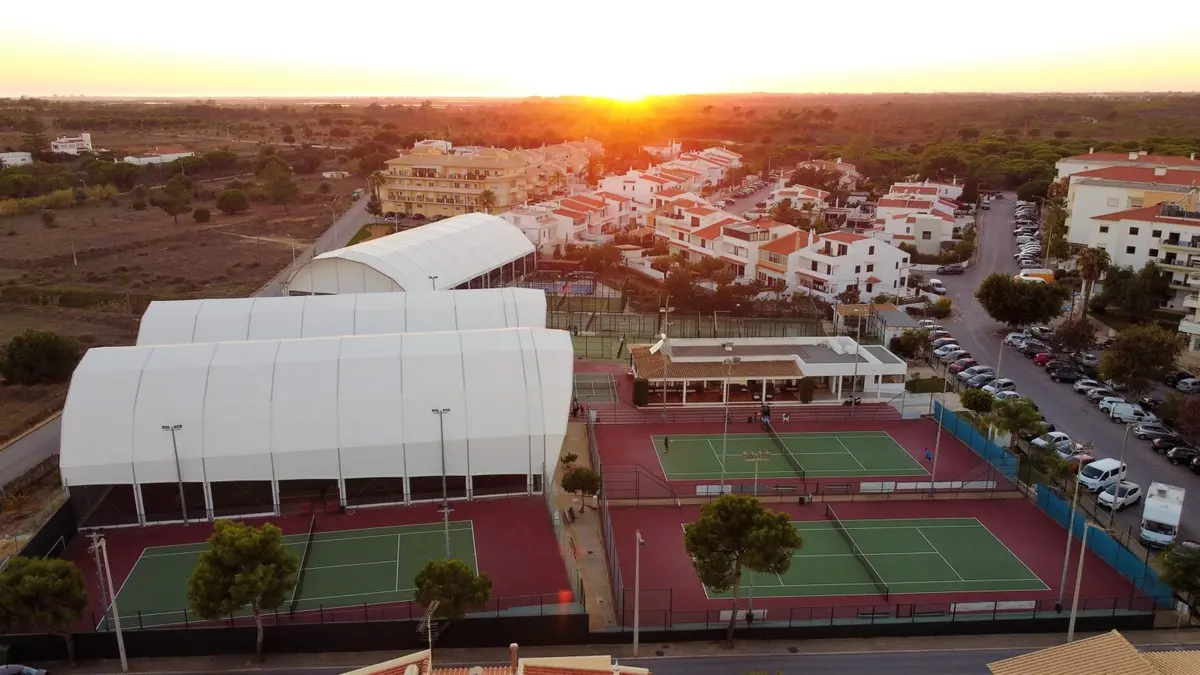 Aerial view of covered and outdoor tennis courts at the Faro tennis centre at sunset