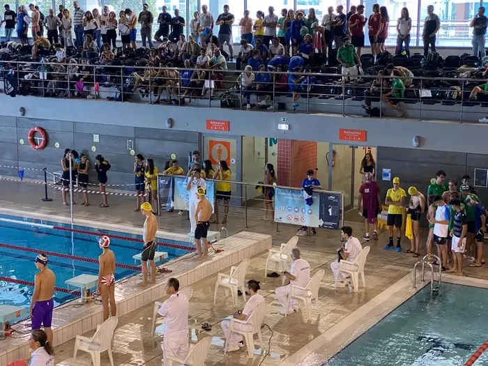 Swimmers and spectators beside the indoor swimming lanes at Lagos em Forma