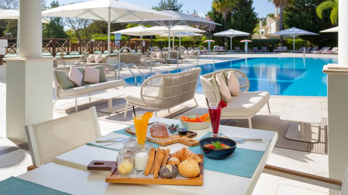 Breakfast table on the terrace beside the outdoor Pool Hangout at Martinhal Quinta