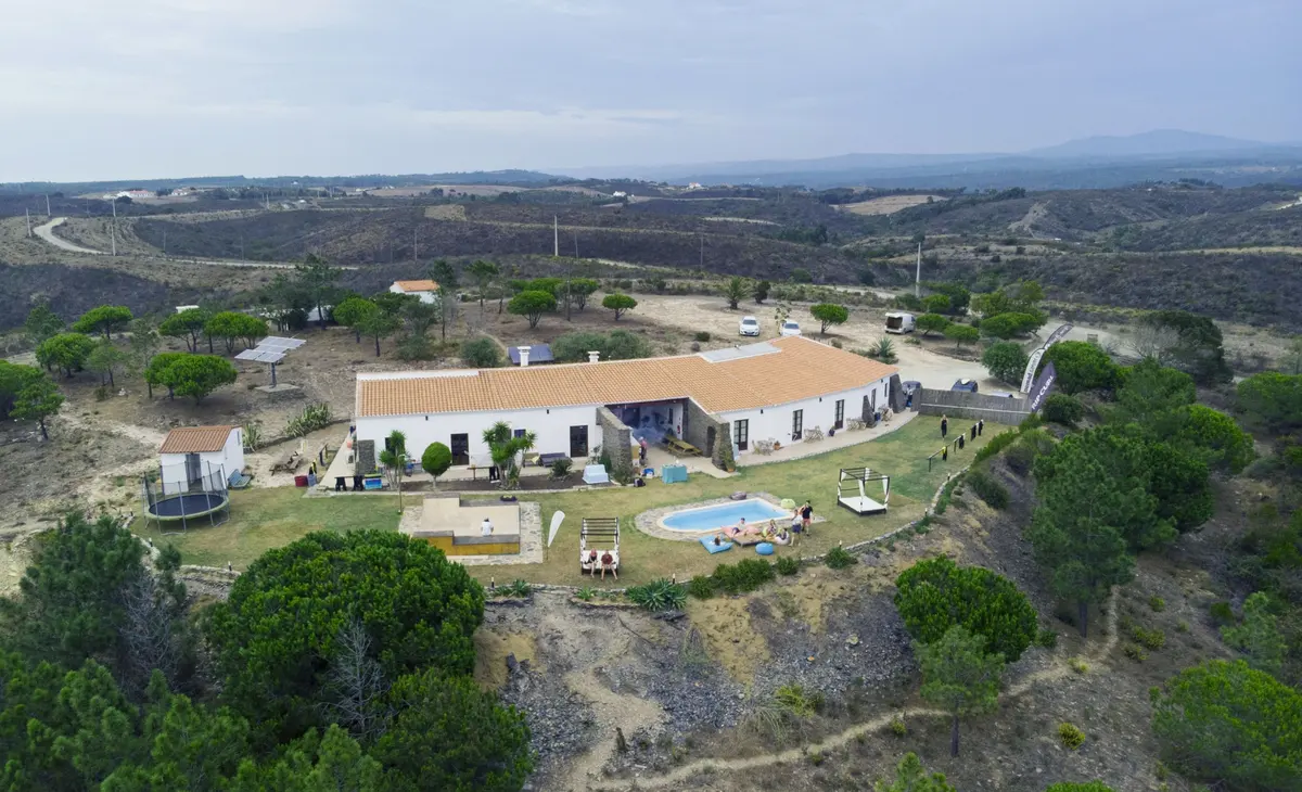 The Russo Surf Camp buildings, lawn and pool among the hills