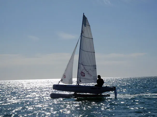 A small sailing catamaran on the water off Praia da Luz