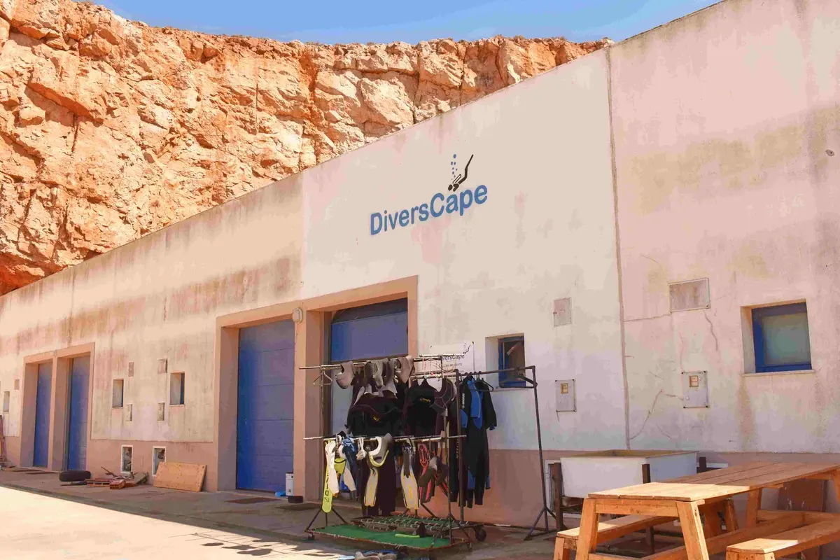 The Divers Cape building with diving equipment outside at Sagres harbour