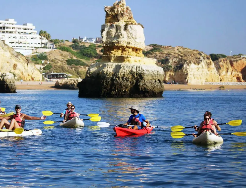 A group of kayakers off the rock formations by Dona Ana beach in Lagos