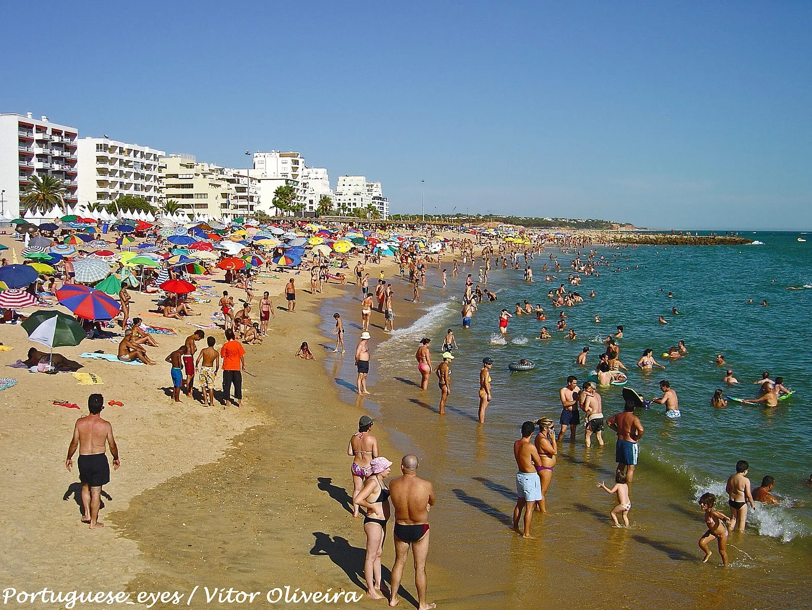 Beachgoers and seafront buildings at Quarteira