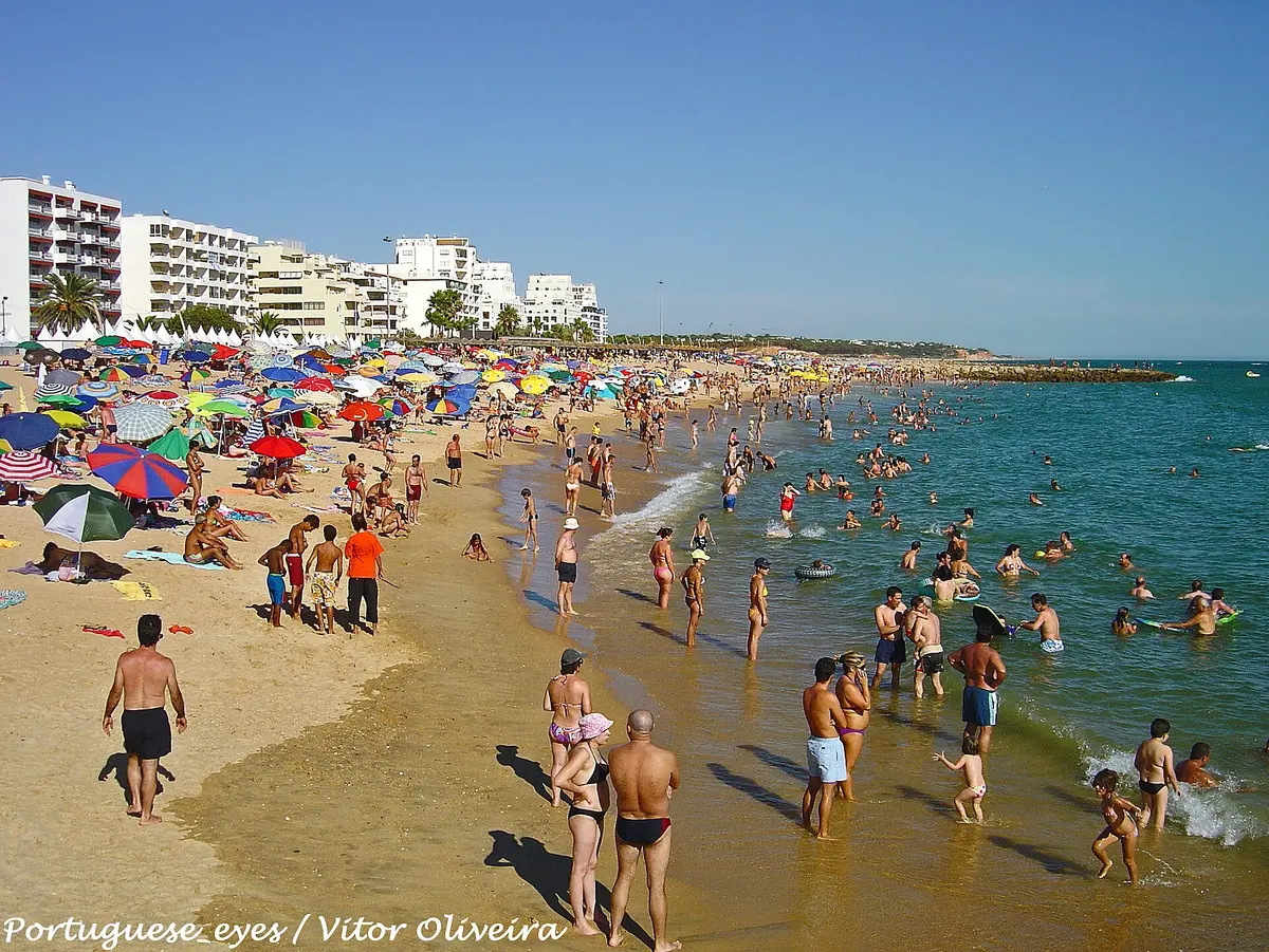 Beachgoers and seafront buildings at Quarteira