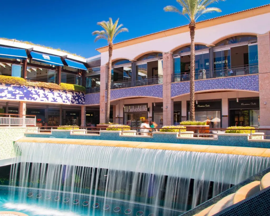Palm trees, shopfronts and the central water feature at Forum Algarve