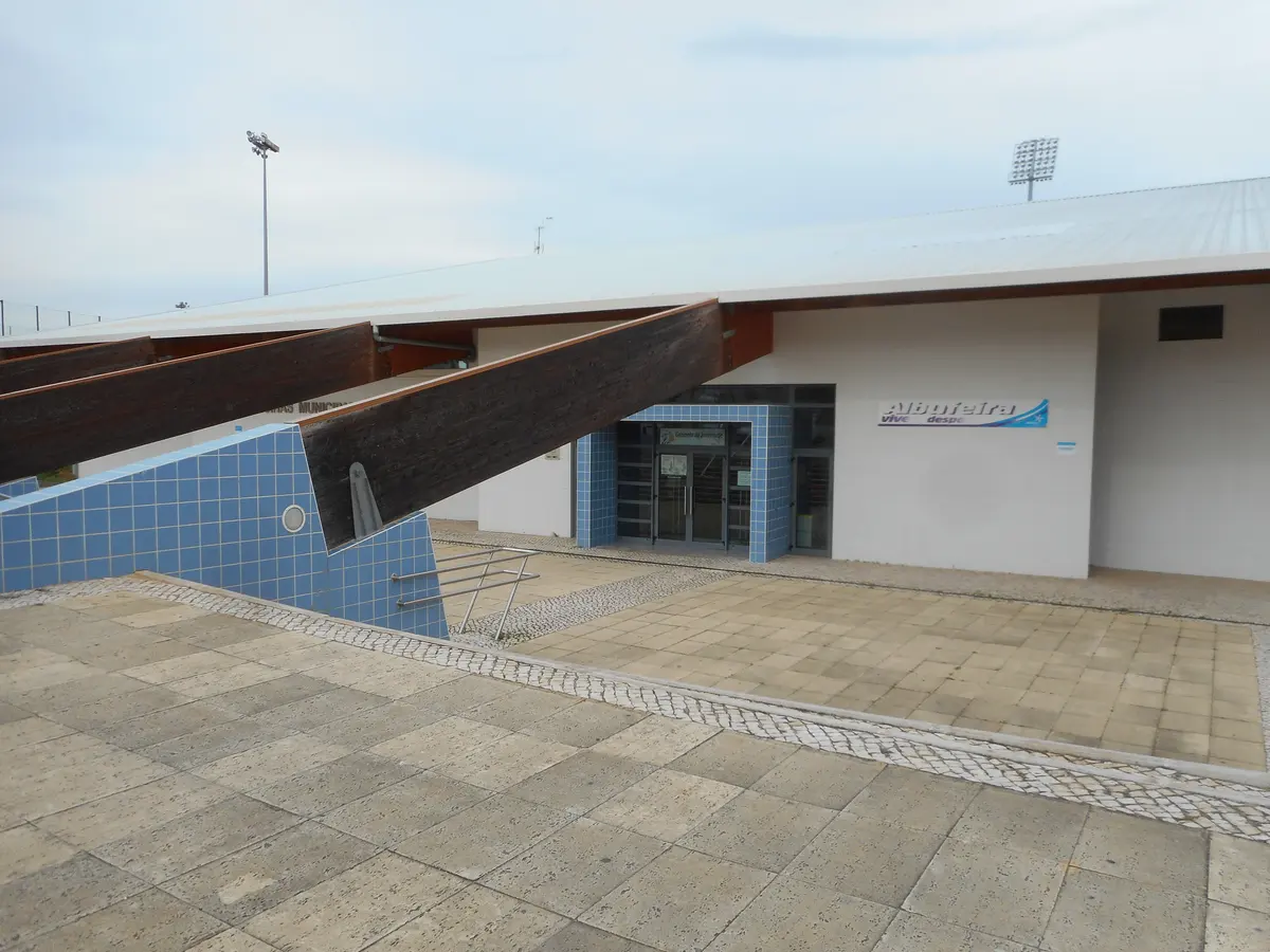 Blue-tiled entrance and timber beams outside Albufeira Municipal Pools